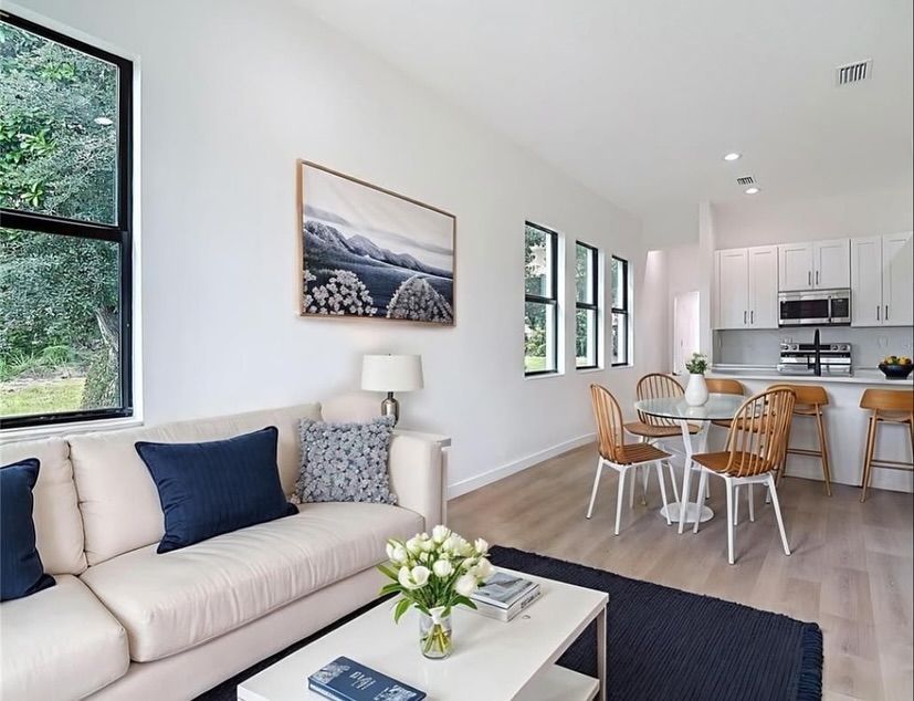 Modern living room with white walls, light wood floors, and minimalist furniture.