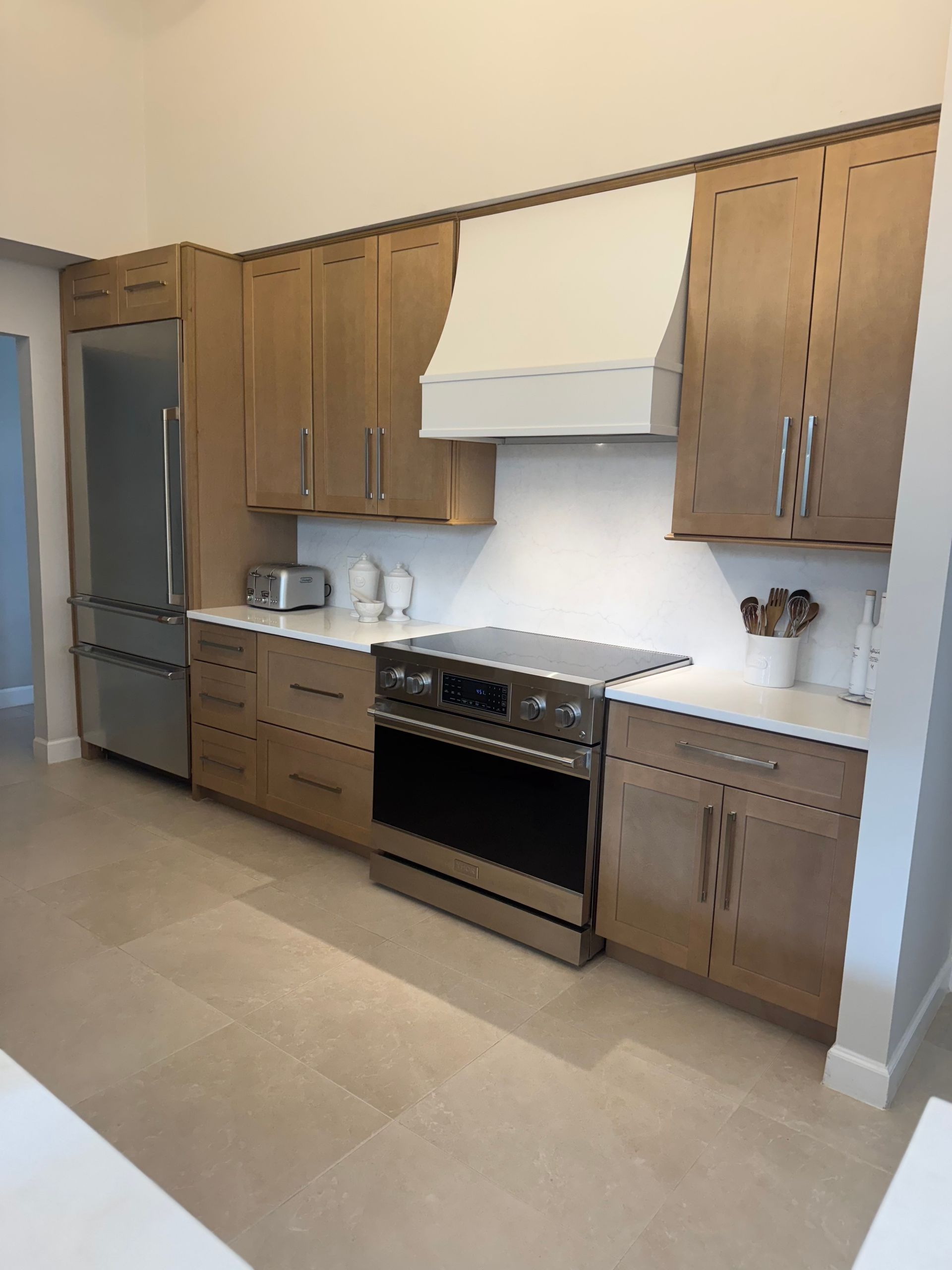 Kitchen with light wood cabinets, stainless steel appliances, and white countertops.