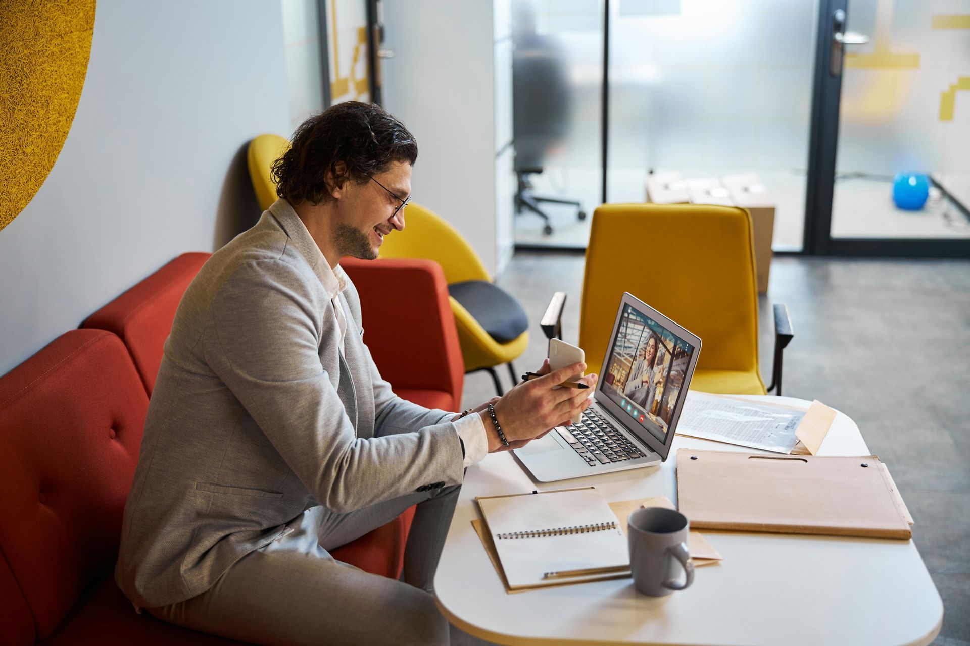 A man is sitting at a table using a laptop computer.