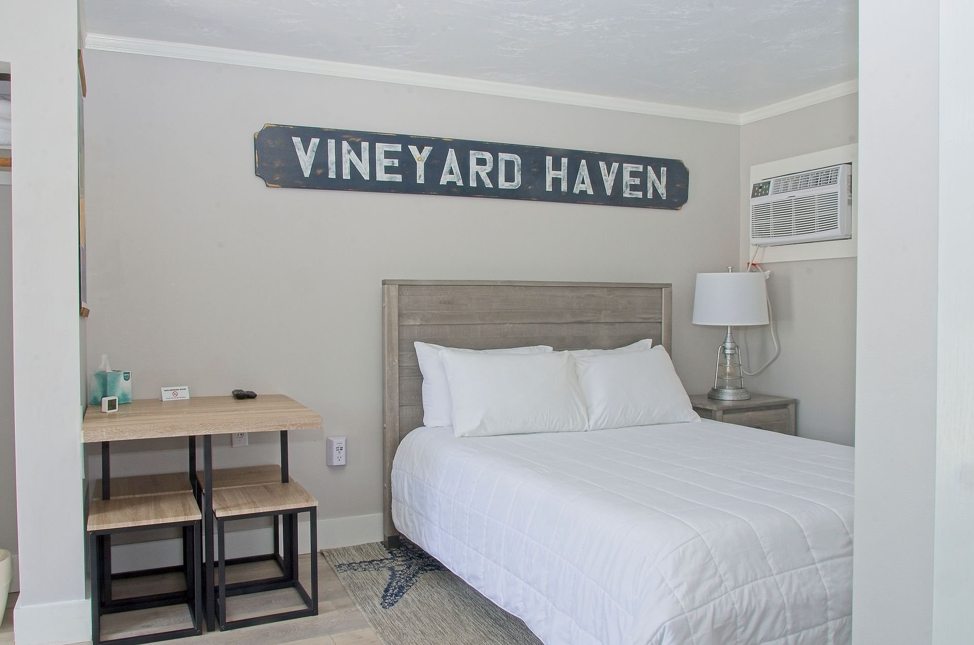 Bedroom with a queen bed, a small desk and chairs, and a