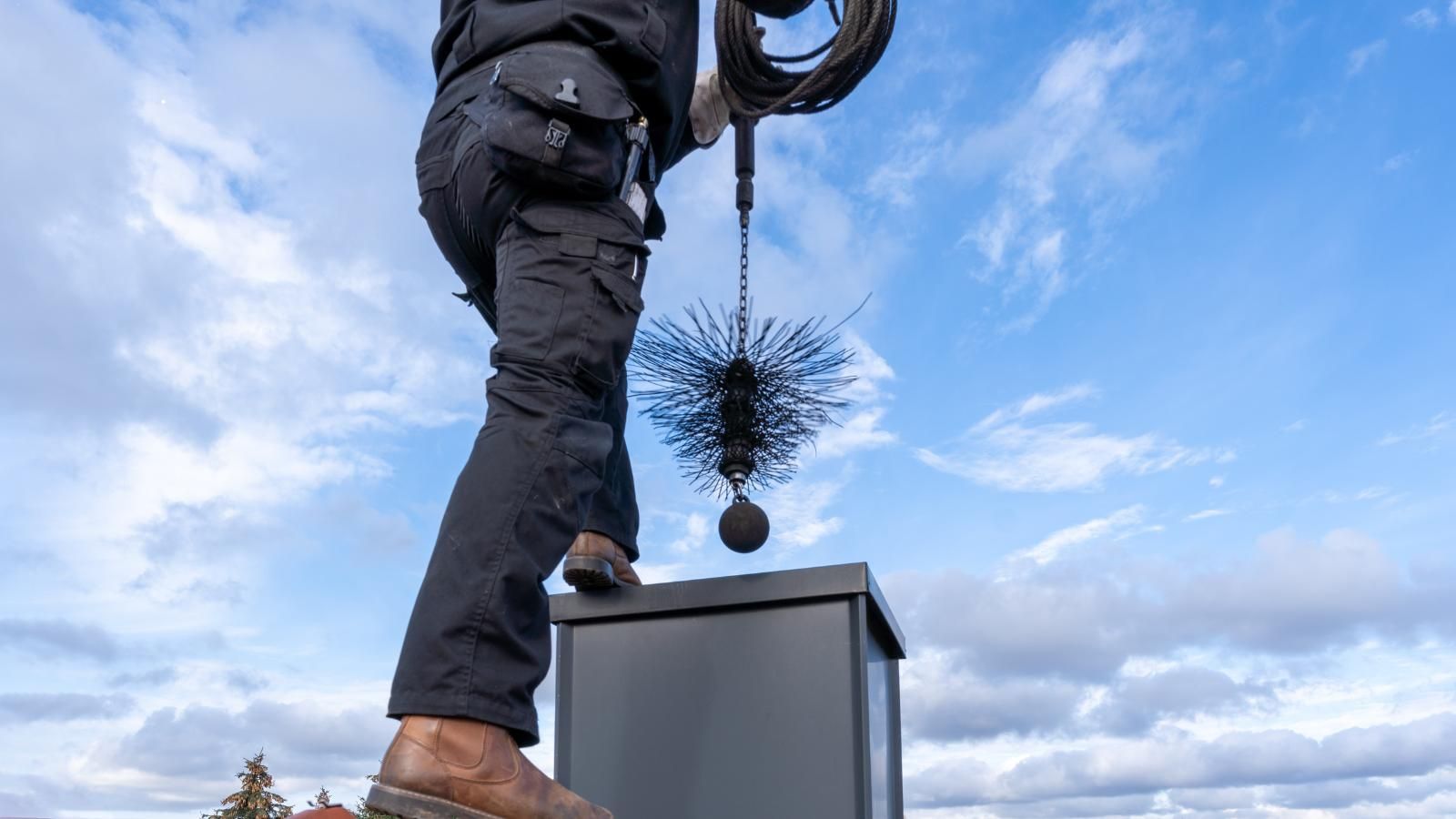 A man is cleaning a chimney with a brush.