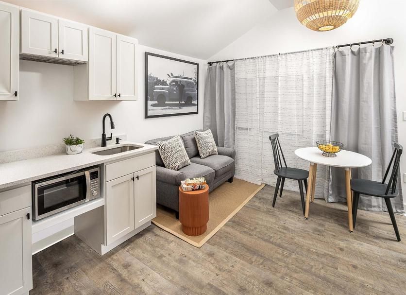 Small studio apartment with a kitchenette, sofa, and dining area.
