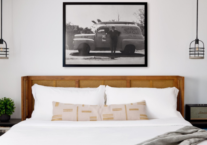 Bedroom with bed, headboard, framed photo, pendant lights, and nightstands.