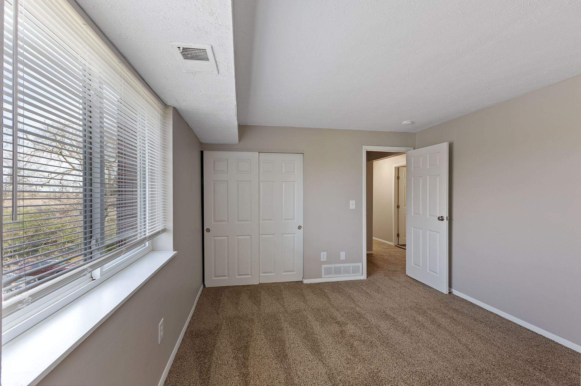 a photo of a bedroom looking outside 