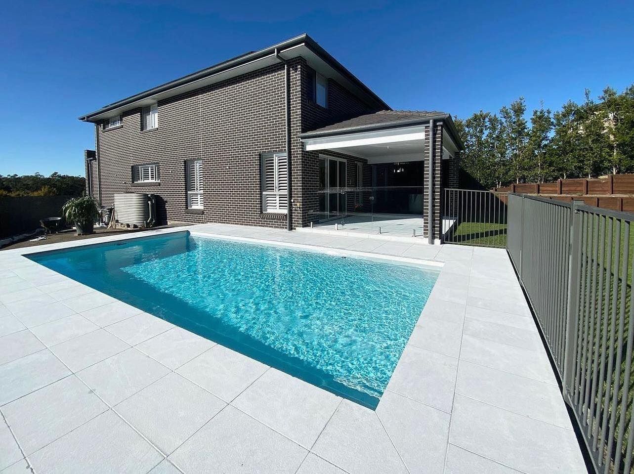 A house with a pool and a covered patio, all on a sunny day. — East Coast Paving in Seaham, NSW