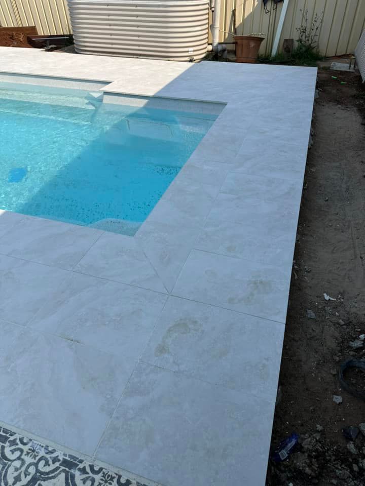 Pool with light gray stone coping and a small built-in step area. — East Coast Paving in Seaham, NSW