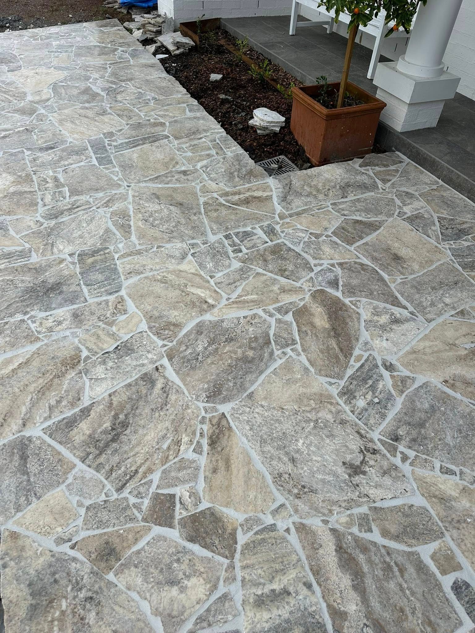 Flagstone patio and walkway in shades of gray and tan, leading to a front porch. — East Coast Paving in Seaham, NSW