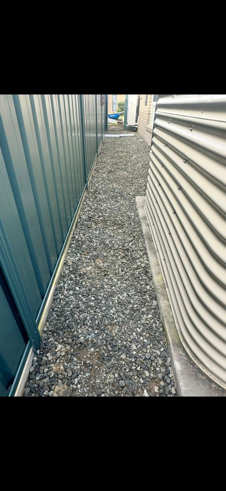 Narrow gravel pathway between corrugated walls. — East Coast Paving in Seaham, NSW