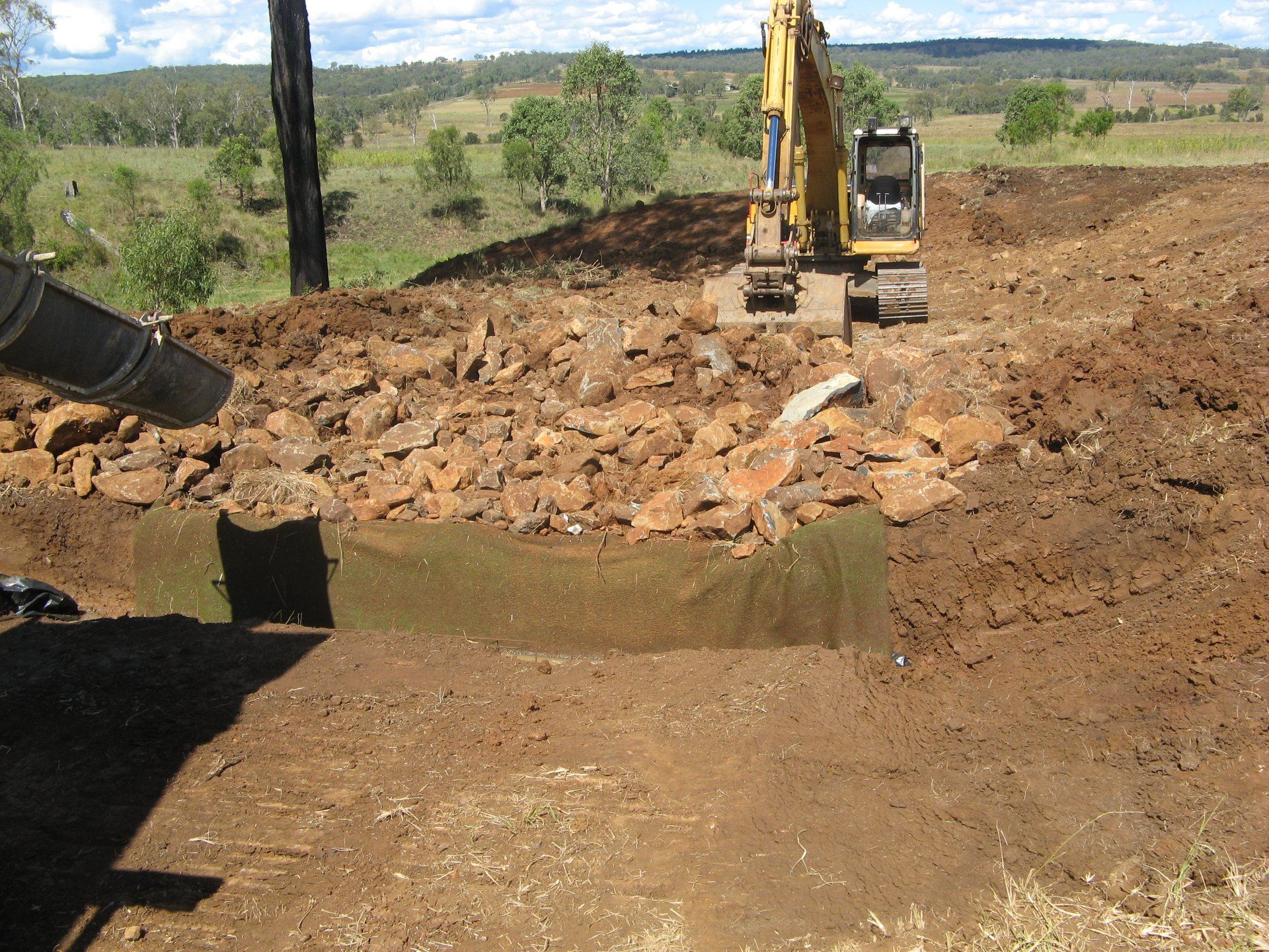 An Excavator Removing And Clearing Large Rocks — Greenslade's Dozer & Excavator Hire Pty Ltd In Taabinga, QLD