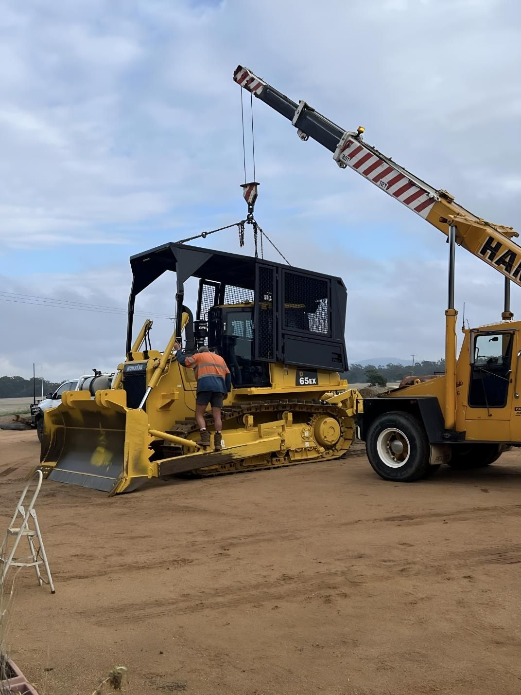A Yellow Bulldozer Is Being Lifted By A Crane — Greenslade's Dozer & Excavator Hire Pty Ltd In Durong, QLD