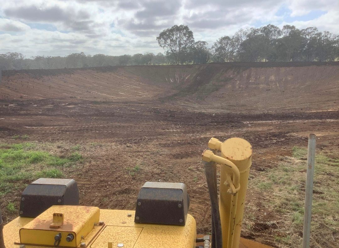 A Large Dirt Field With A Cloudy Sky In The Background — Greenslade's Dozer & Excavator Hire Pty Ltd In Taabinga, QLD