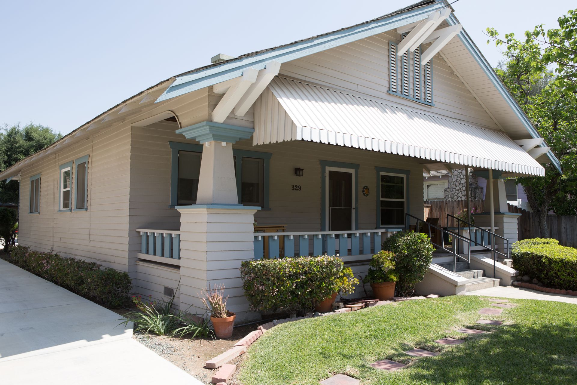 A white house with a white awning on the porch