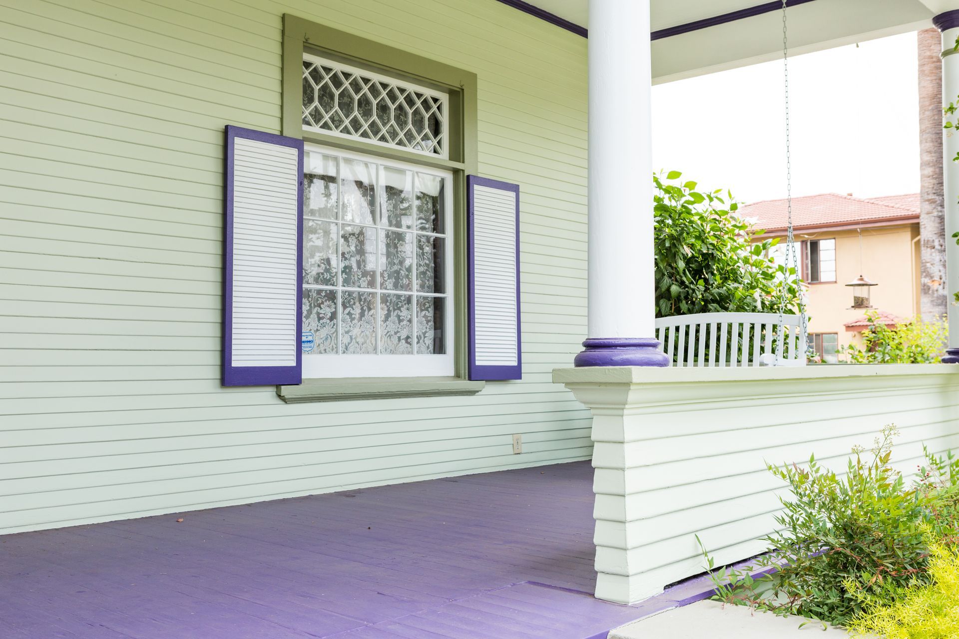 A white house with purple shutters on the windows