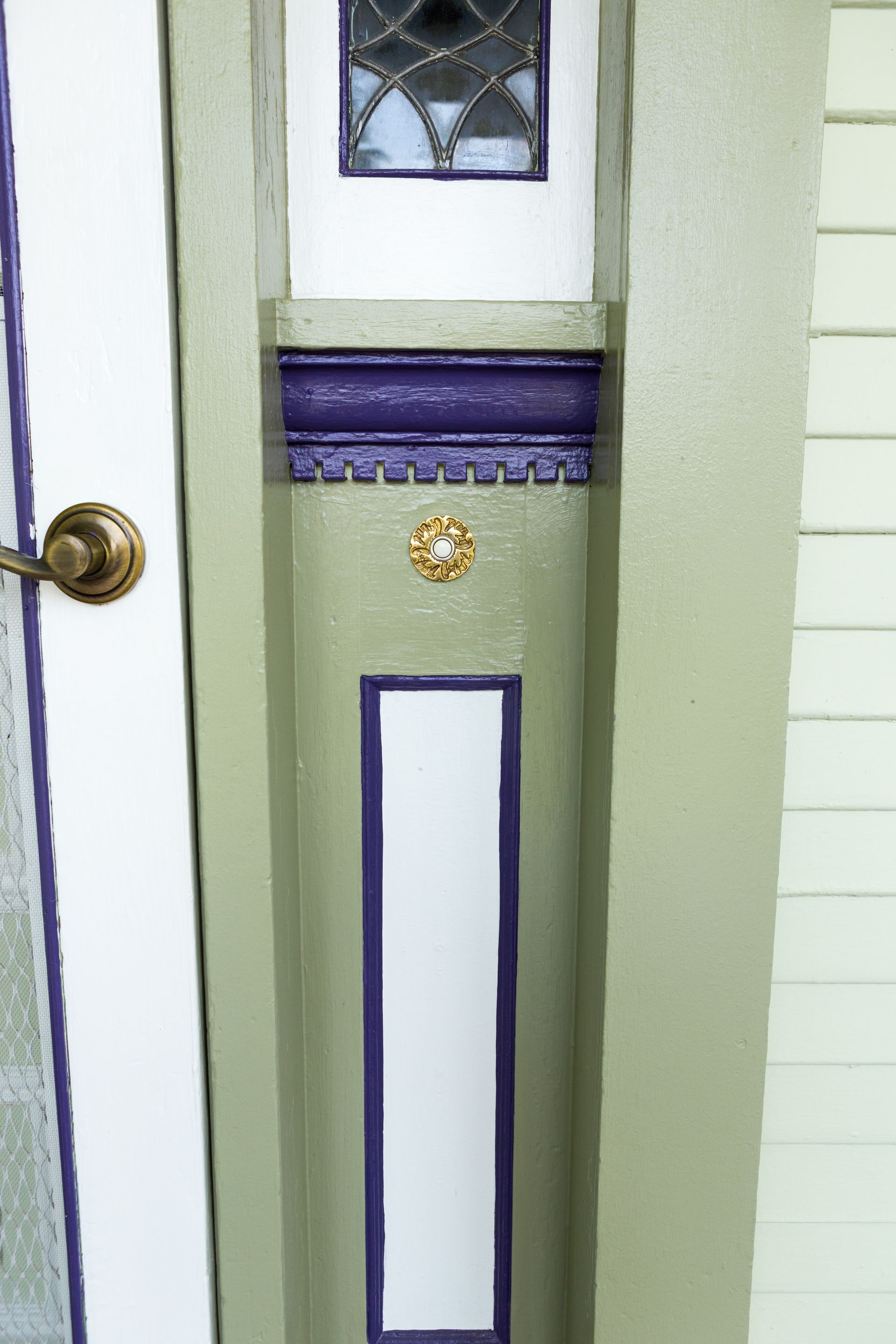 A close up of a door with a purple trim and a stained glass window.