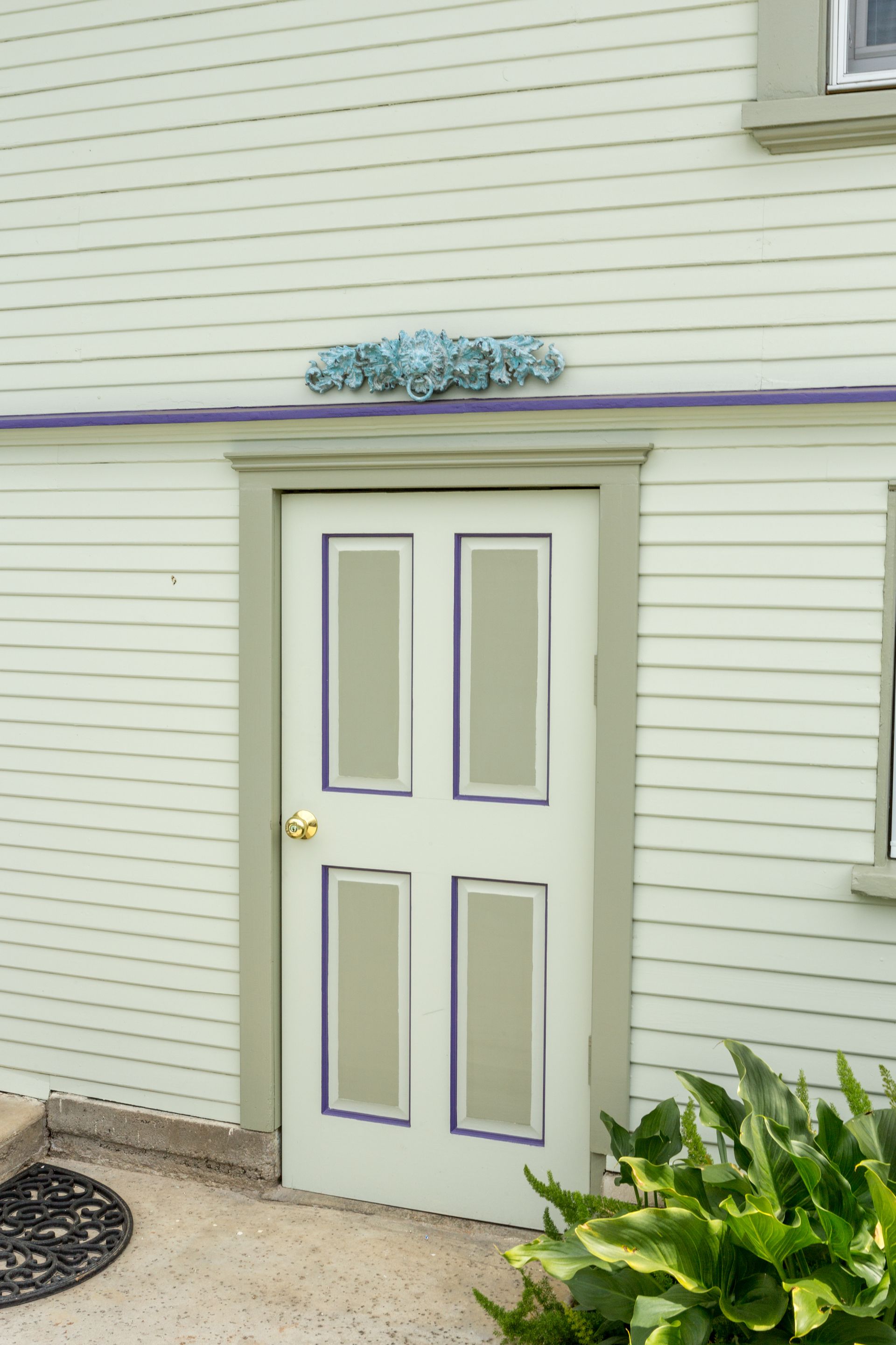 A white house with a white door and a purple trim