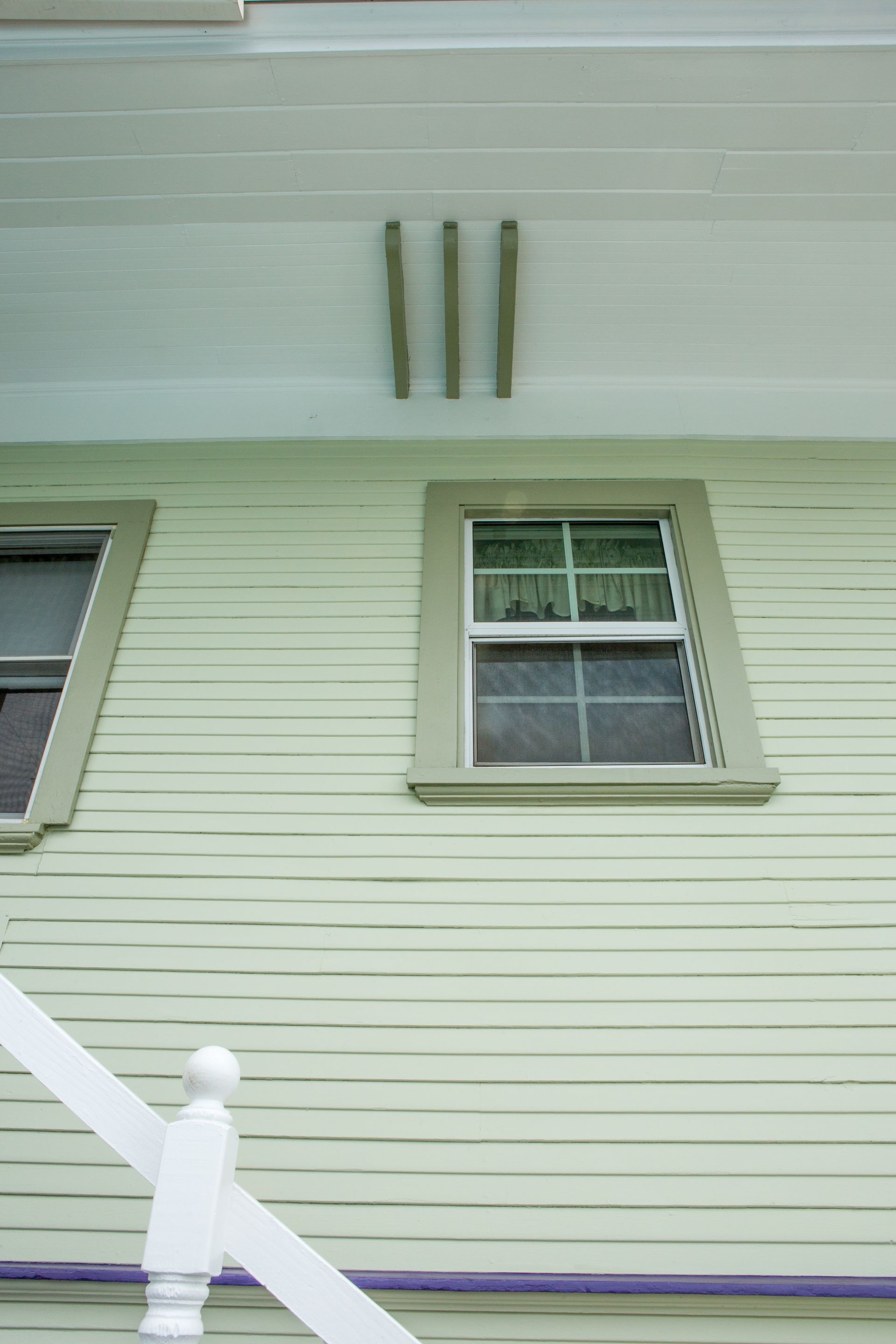 A house with three windows and a purple railing