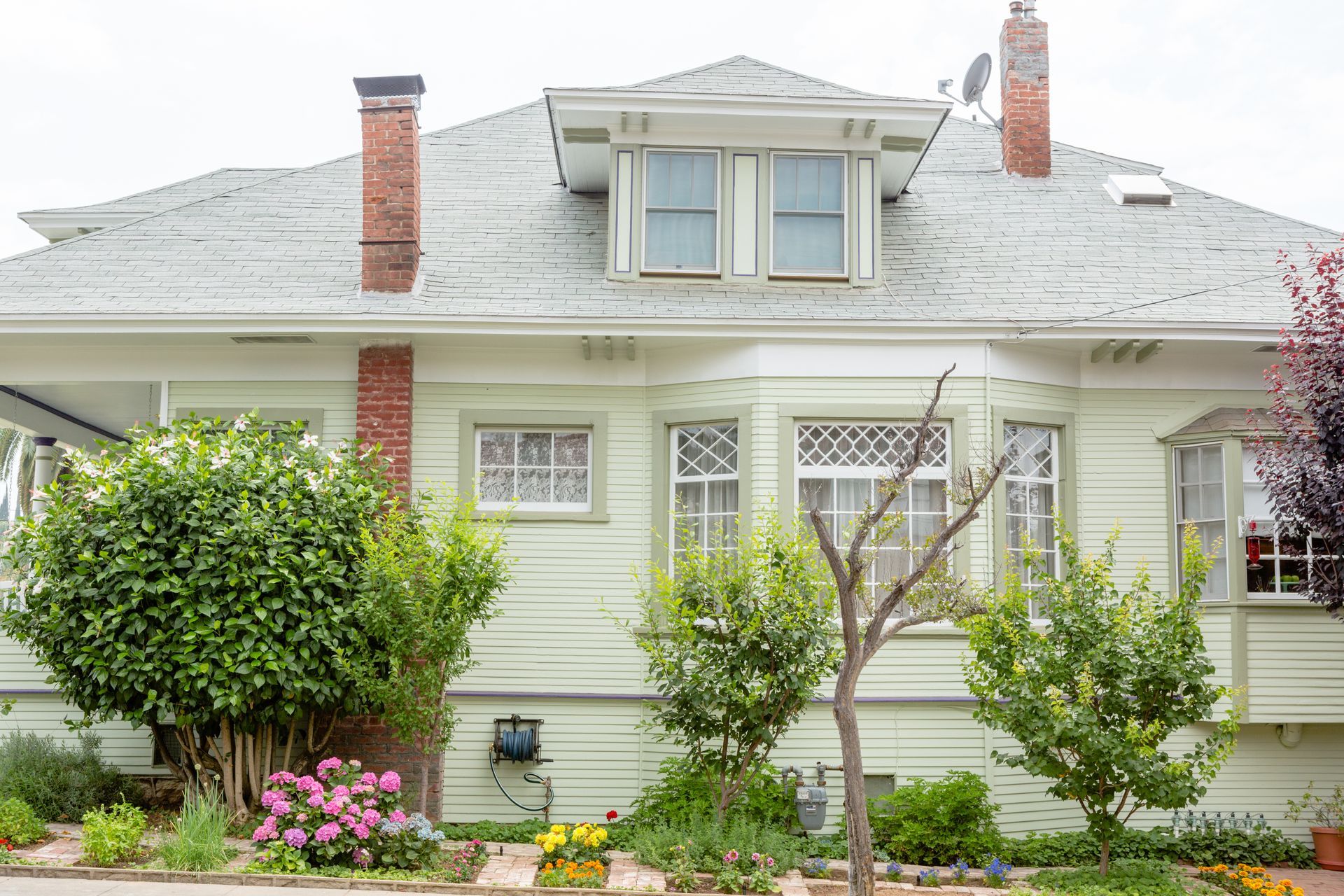 A white house with a brick chimney on the roof