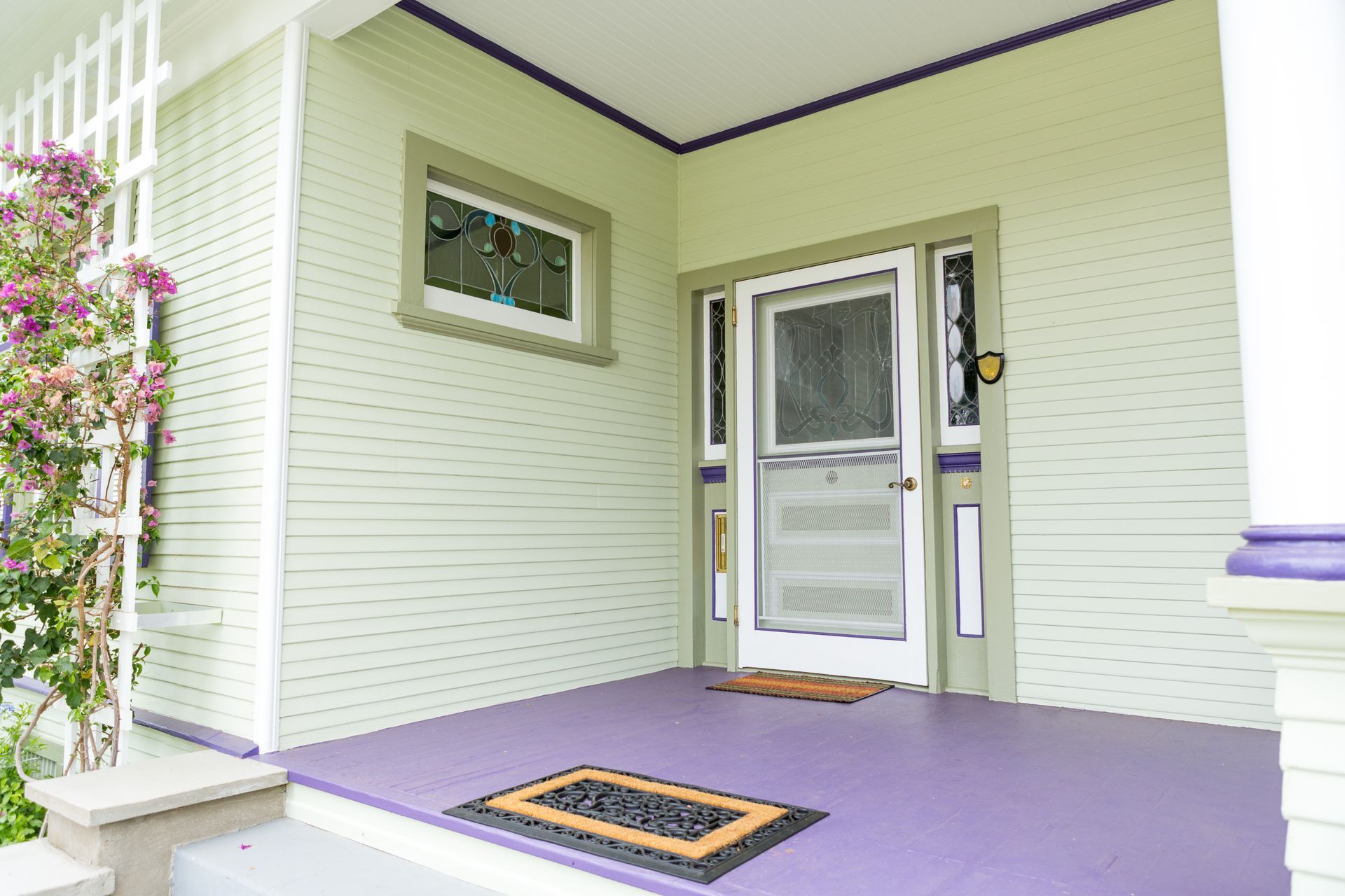 A white house with a purple porch and a purple door