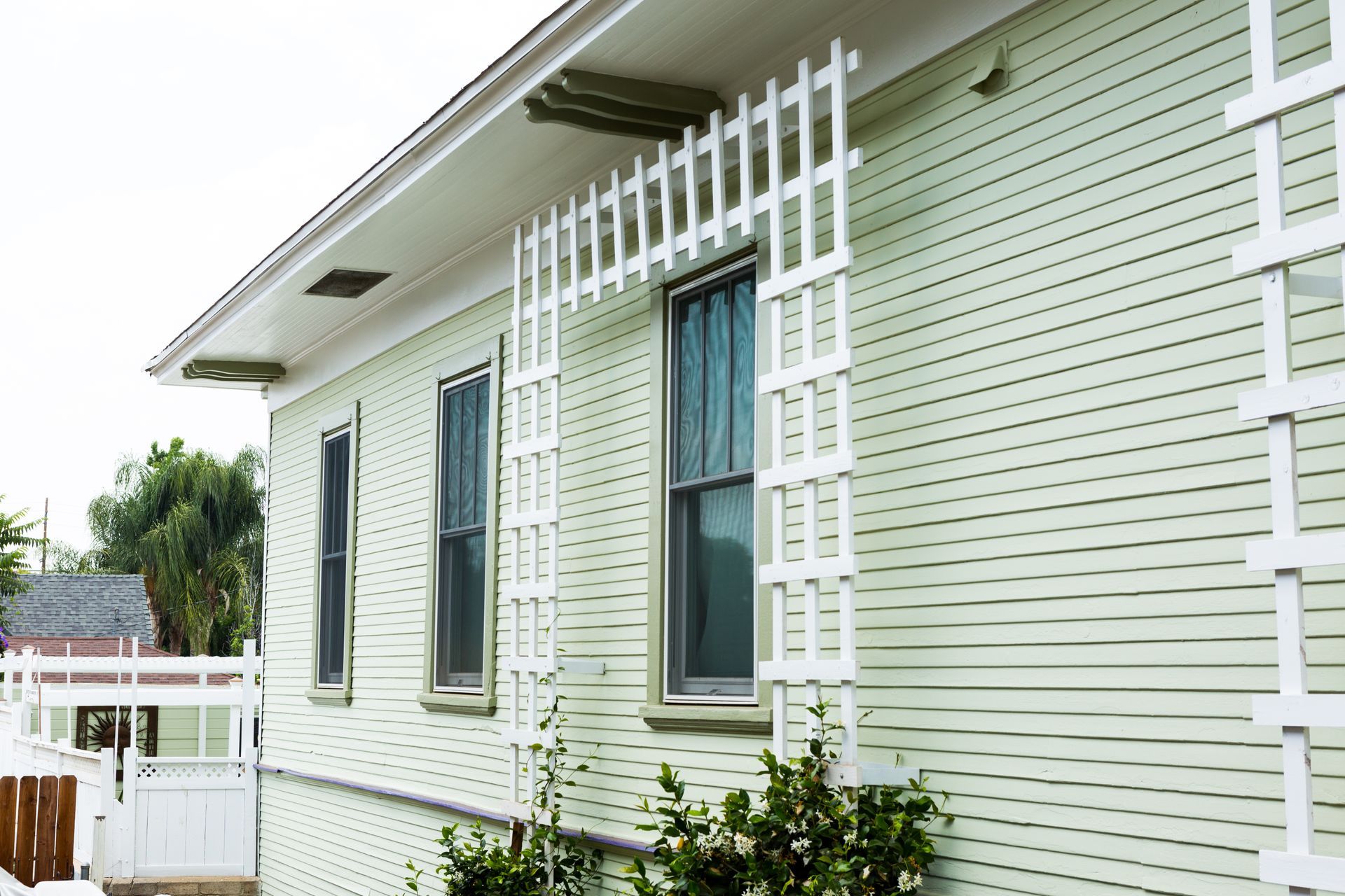 A house with a white trellis on the side of it