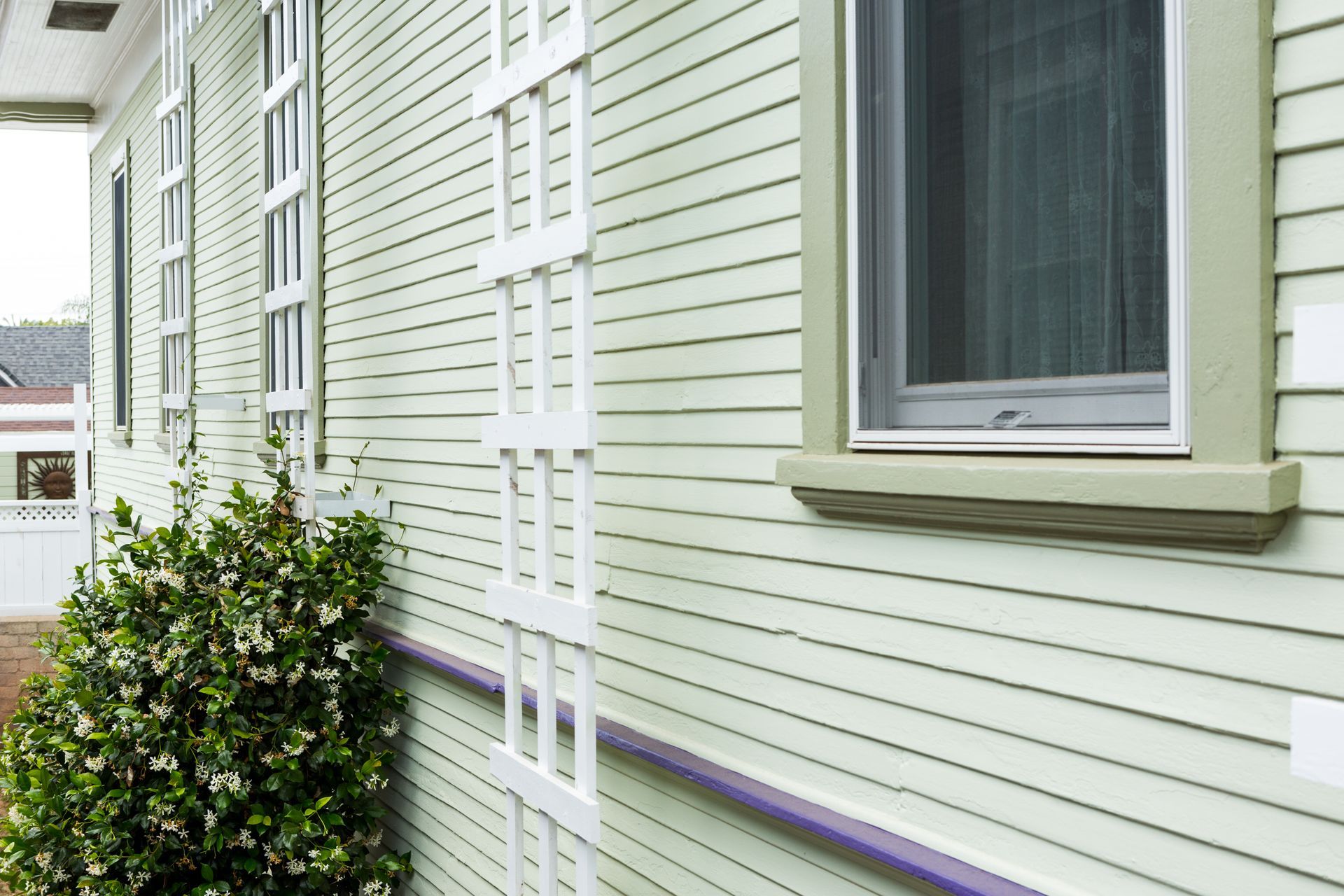 A white house with a purple trim and a window