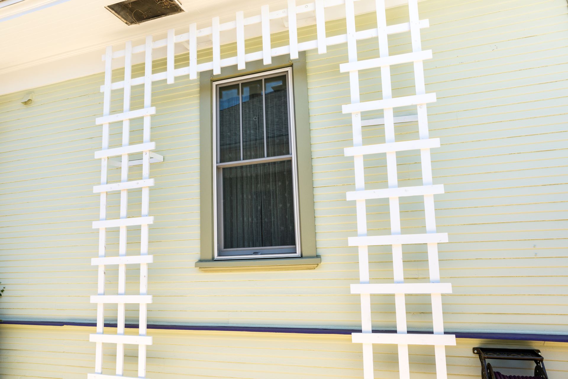 A white lattice is attached to the side of a house