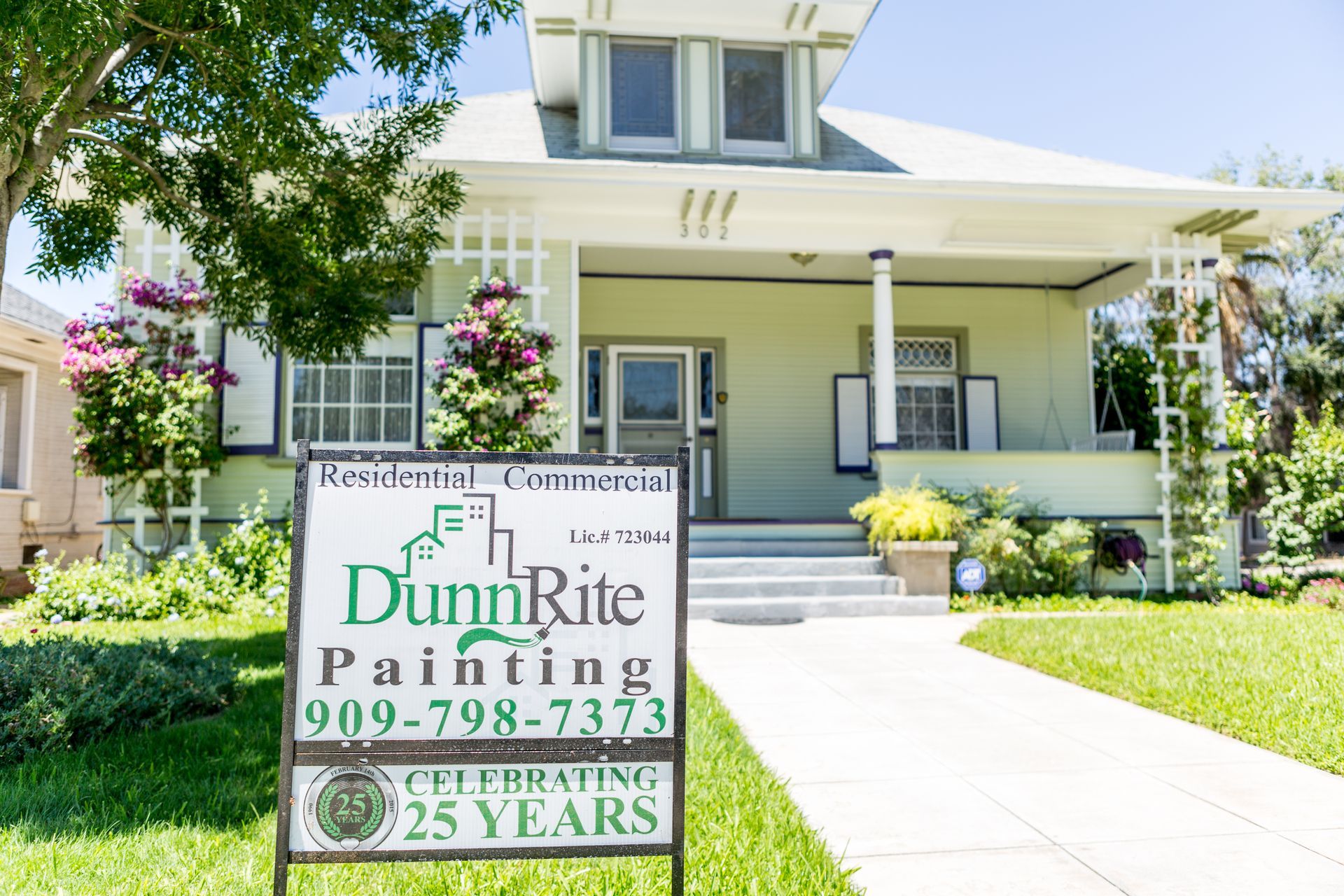 A sign for dunn rite painting is in front of a house