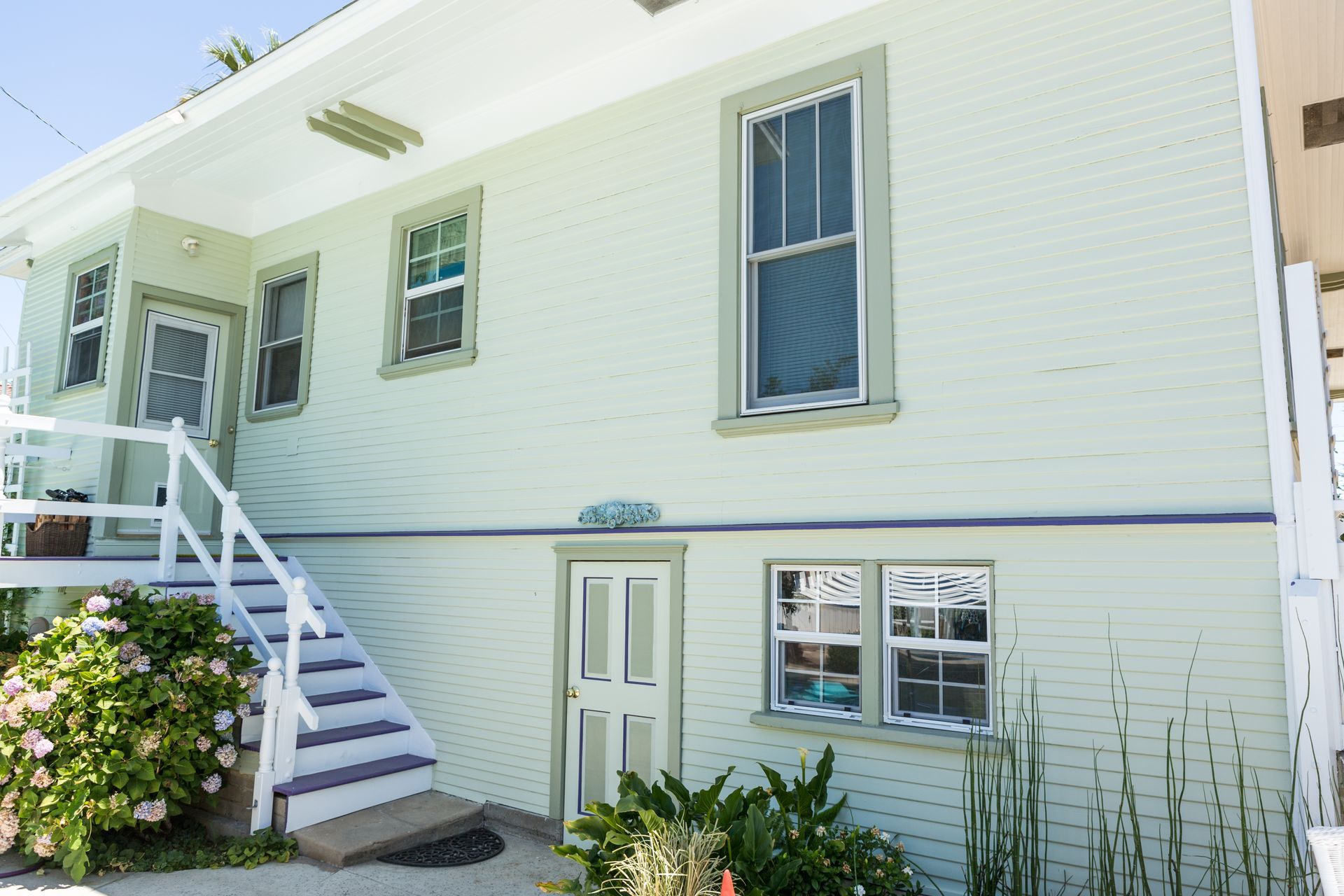 A white house with stairs leading up to the front door