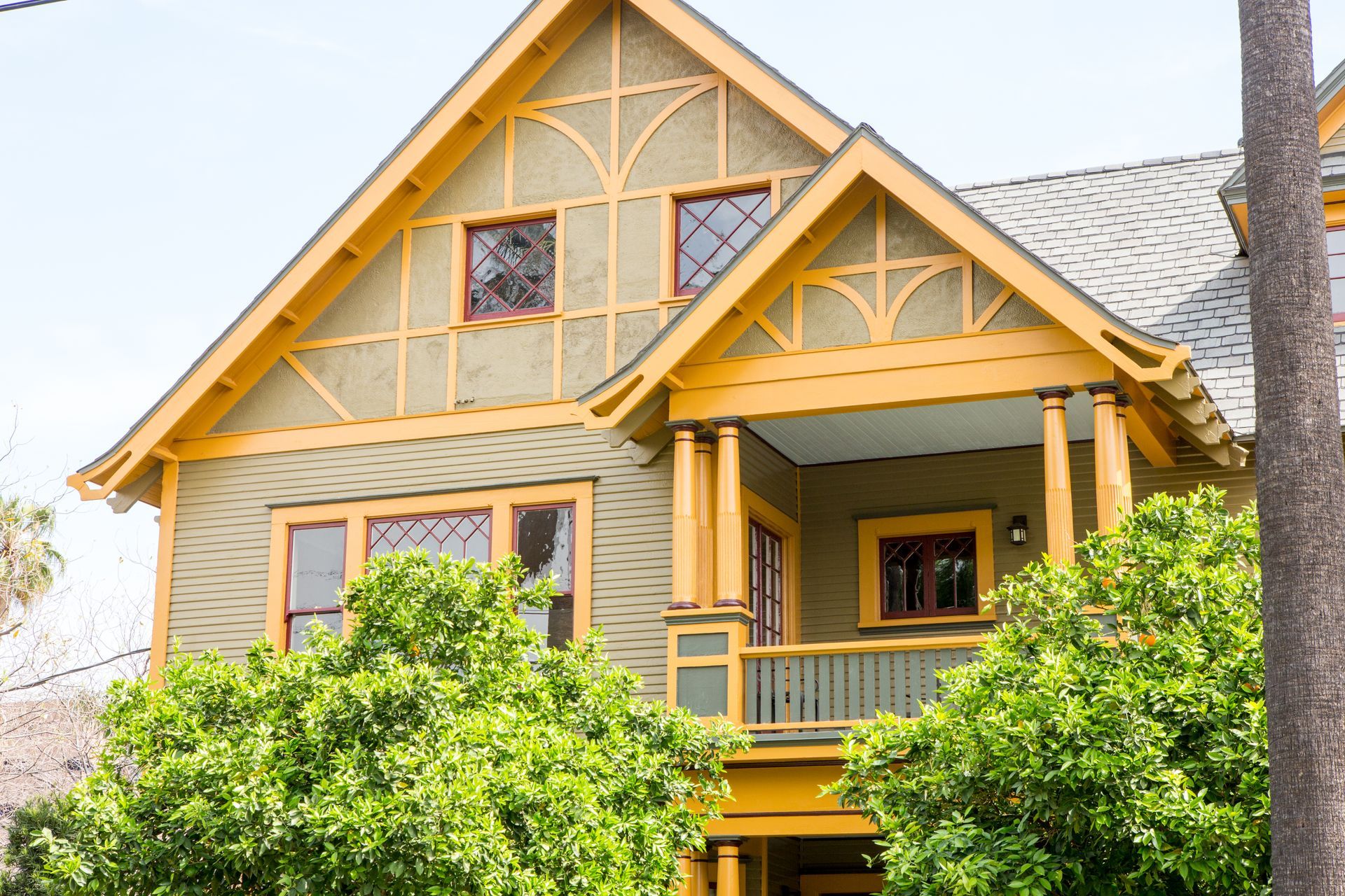 A house with a yellow porch and a gray roof