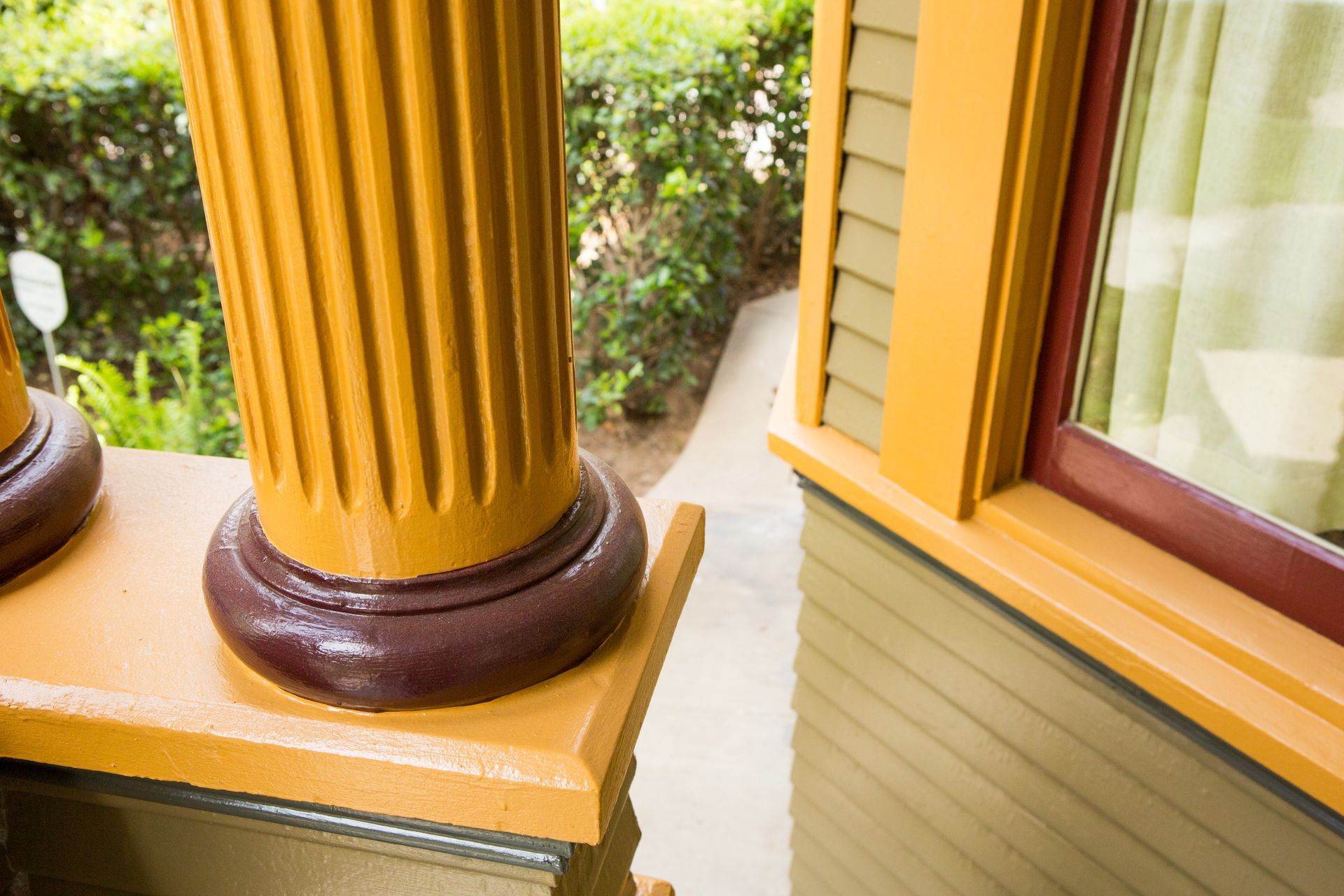 A close up of a porch with columns and a window
