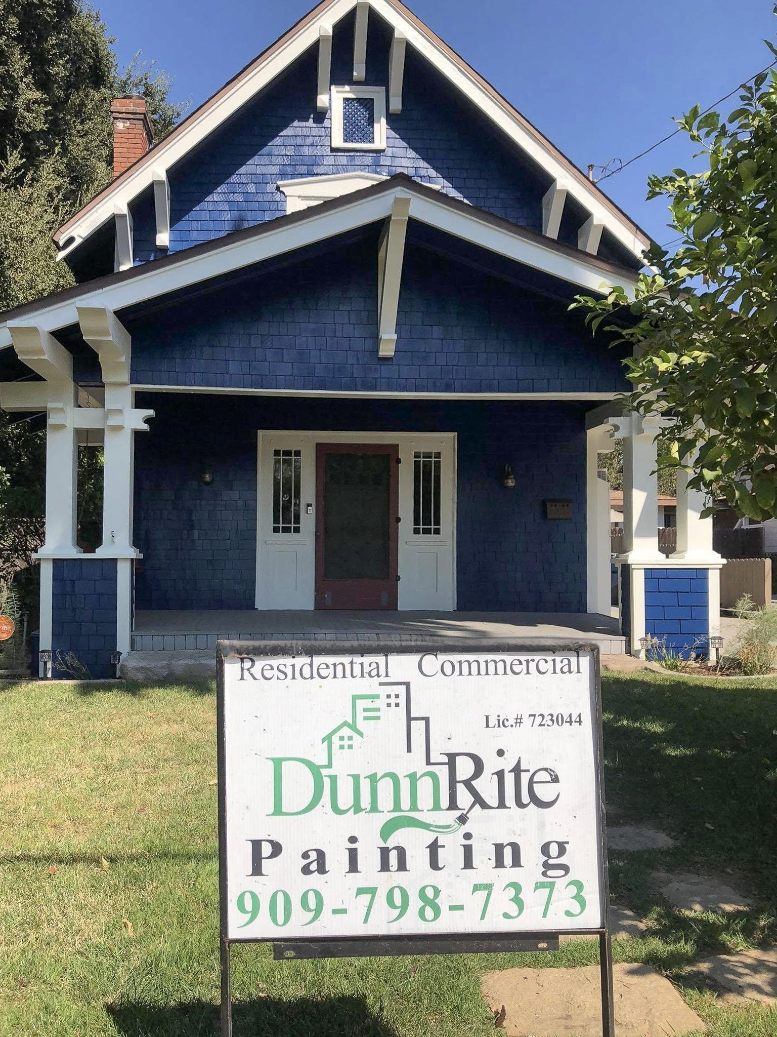 A blue house with a sign in front of it that says dunn rite painting
