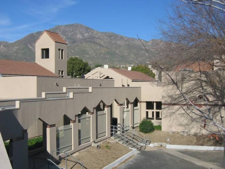 A large building painted Beige with a mountain in the background