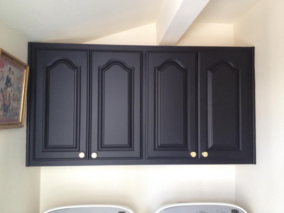 Black cabinets with gold handles in a laundry room