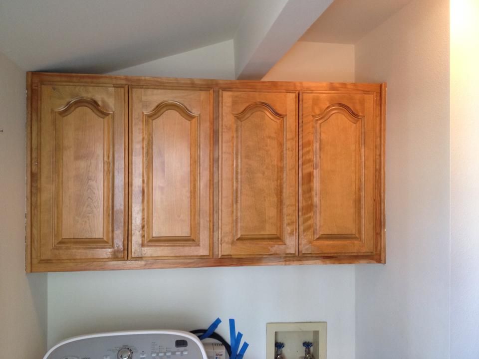 A laundry room with wooden cabinets and a washer and dryer