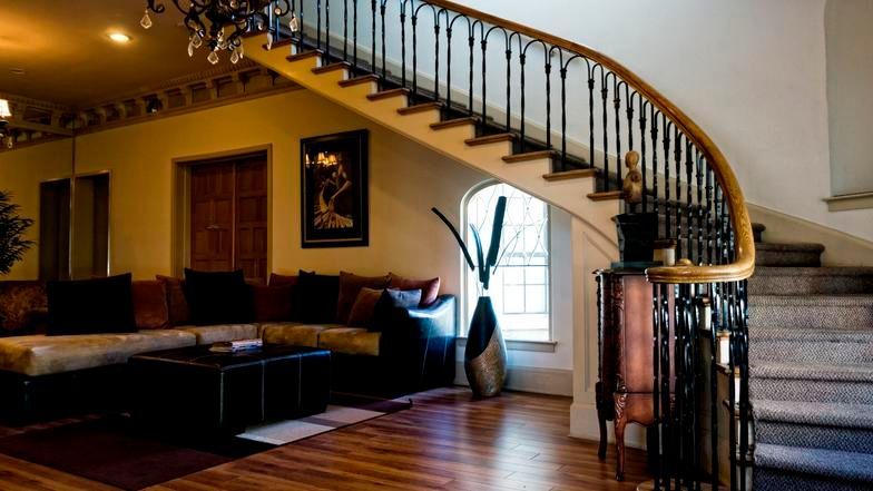A living room with a curved staircase and a couch.