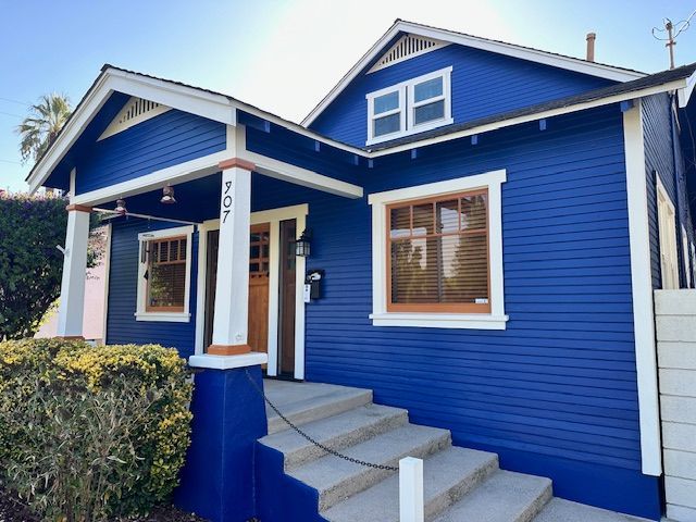 A blue house with white trim and stairs
