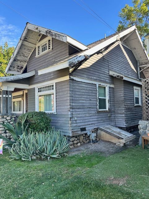 A gray house with a white roof and a lot of windows