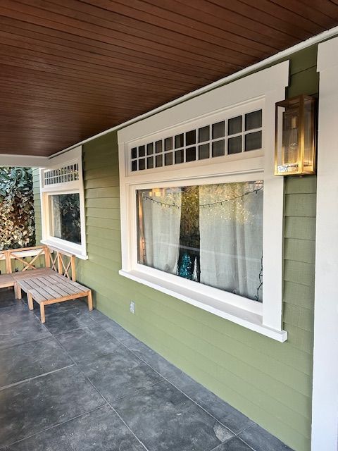 A green house with white trim and a large window