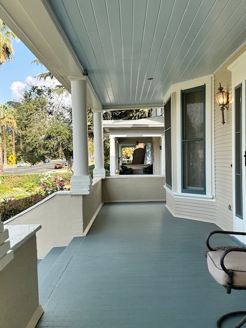 A porch with a chair and a lamp on it