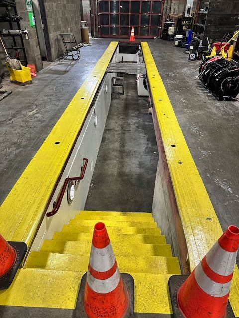 A garage with stairs and orange and white traffic cones