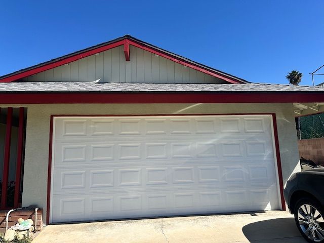 A car is parked in front of a white garage door