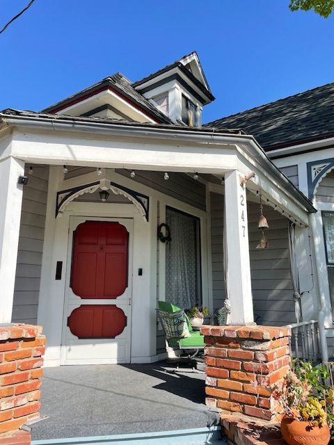 A white house with a red door and a porch