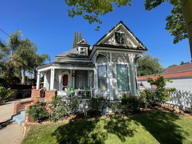 A white house with a porch and a blue sky in the background