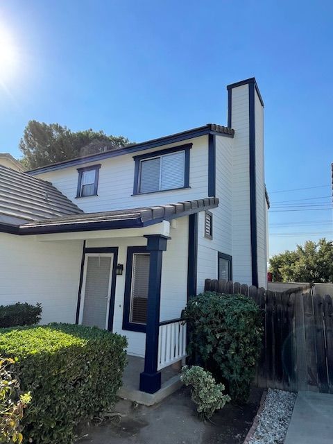 A white house with a chimney on the side of it