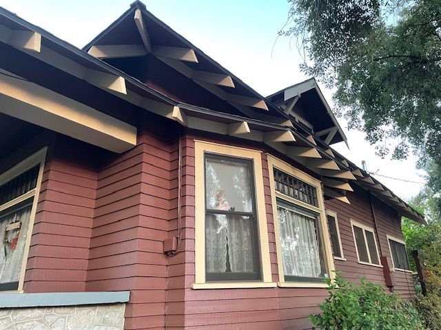 A red house with a roof and a lot of windows