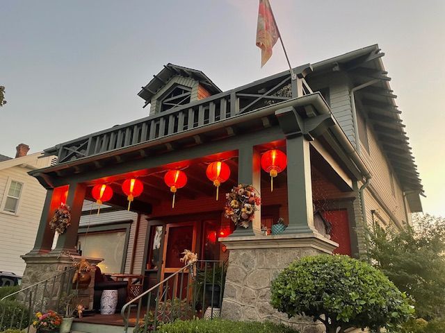 A house with red lanterns and a flag on the porch