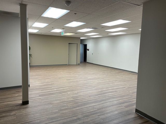 A large empty room with hardwood floors and white walls