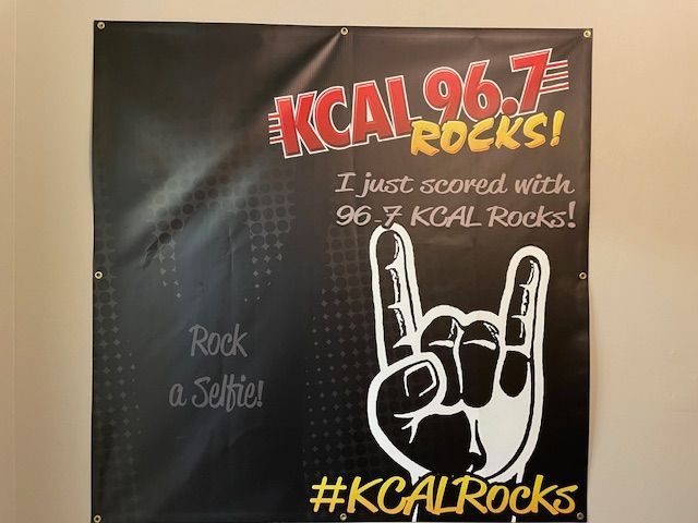 A sign that says kcal 96.7 rocks on it
