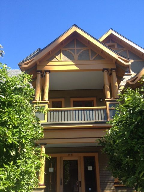 A house with a balcony and a blue sky in the background
