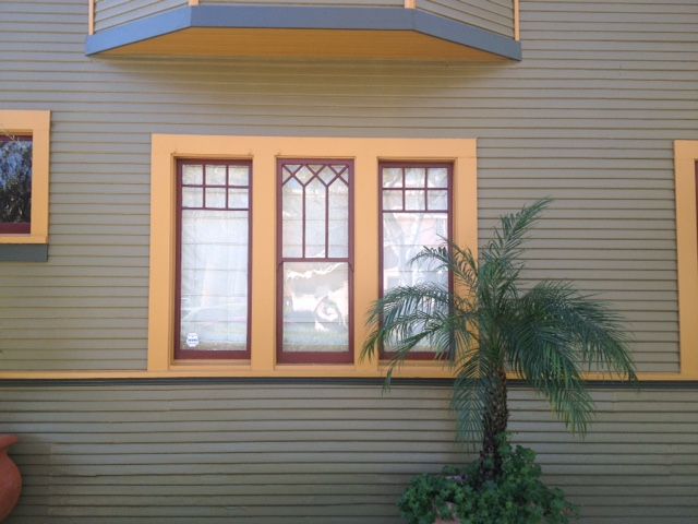 A house with a balcony and a palm tree in front of it