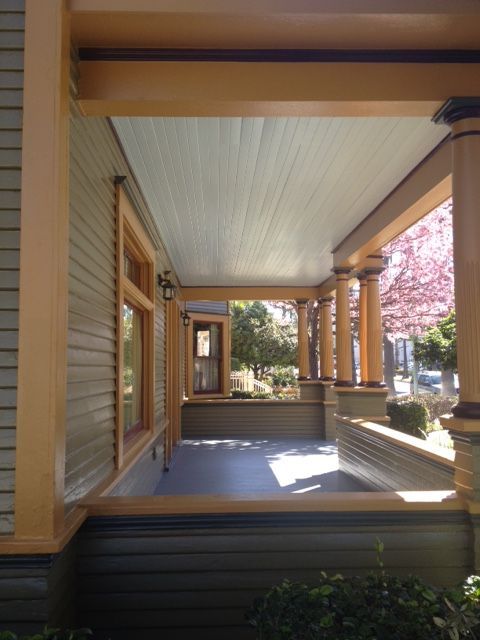 A porch of a house with a cherry blossom tree in the background